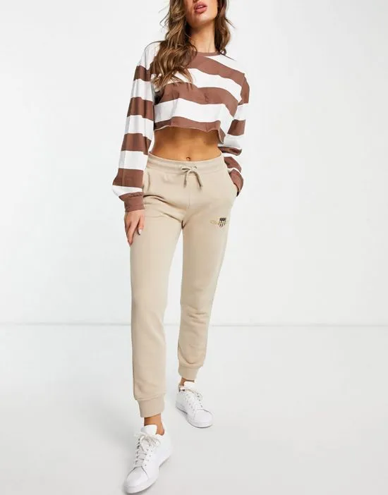 https://images.styletyx.com/images/gant-archive-shield-sweat-pant-in-sand-gant-2265107_4.webp