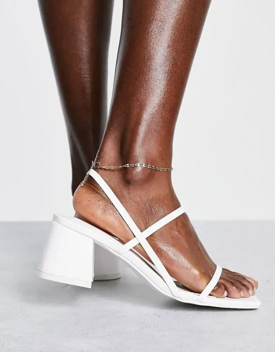 https://images.styletyx.com/images/just-realise-strappy-mid-heel-sandals-in-white-pu-public-desire-2801952_1.webp