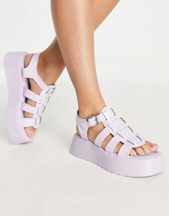 https://images.styletyx.com/images/riakuma-chunky-fisherman-sandals-in-lilac-lilac-koi-footwear-2497013_1.webp