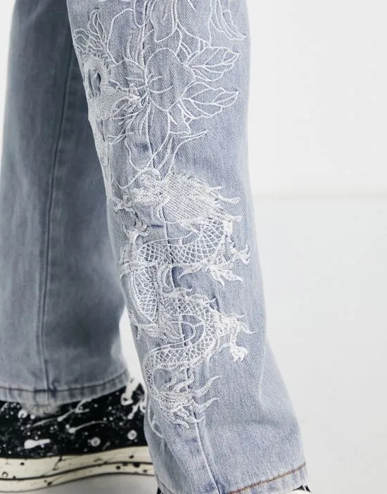 https://images.styletyx.com/images/straight-leg-denim-jeans-in-midwash-blue-with-dragon-and-floral-embroidery-liquor-n-poker-2951502_4.webp