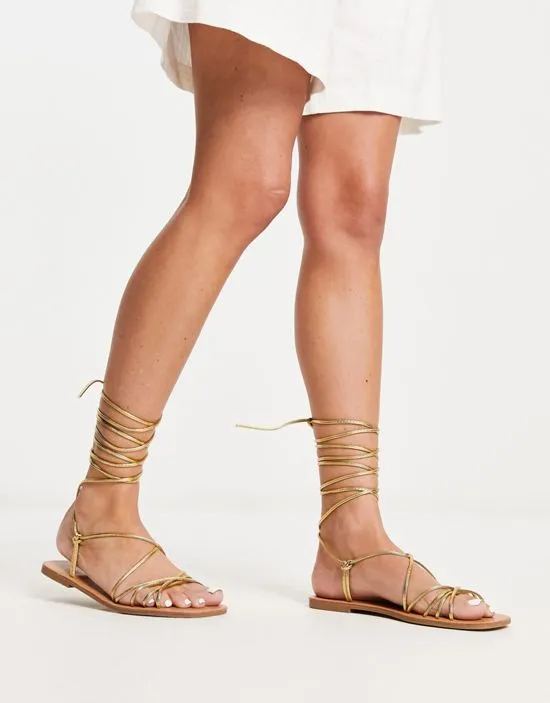 https://images.styletyx.com/images/strappy-tie-leg-flat-sandals-in-gold-metallic-london-rebel-13215597_4.webp