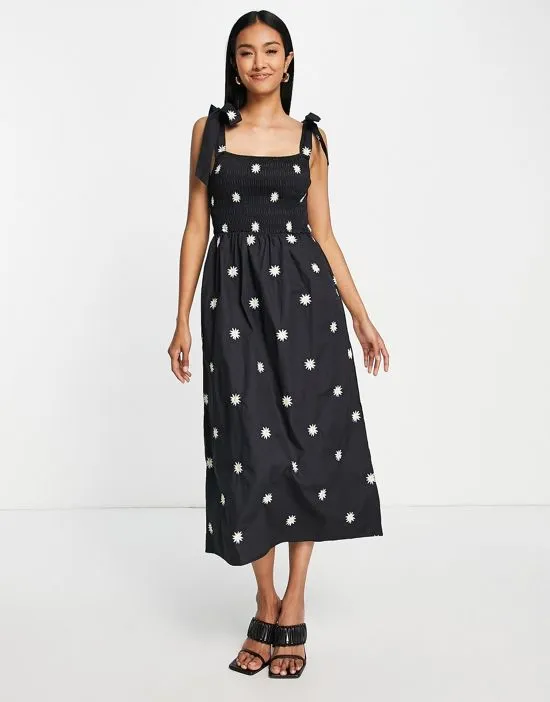 https://images.styletyx.com/images/tie-shoulder-daisy-embroidered-maxi-dress-in-black-never-fully-dressed-2962338_3.webp