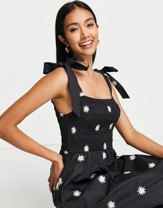 https://images.styletyx.com/images/tie-shoulder-daisy-embroidered-maxi-dress-in-black-never-fully-dressed-2962338_4.webp