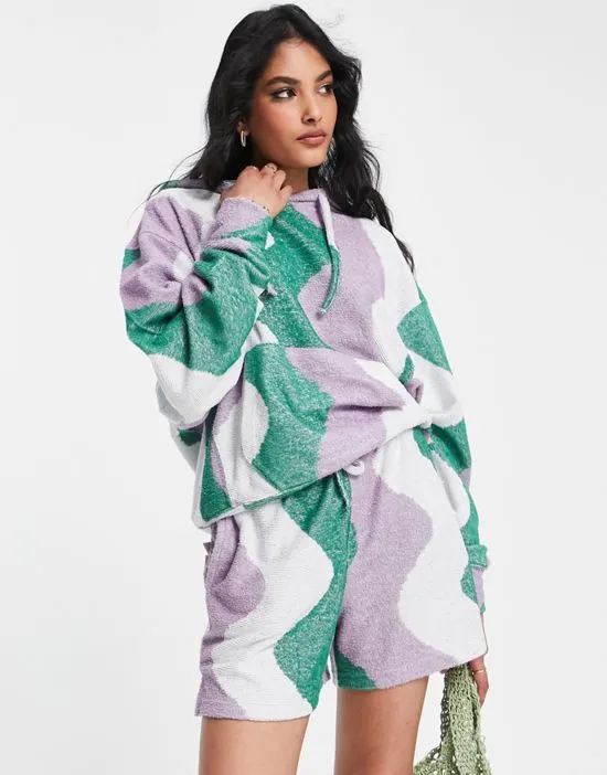 https://images.styletyx.com/images/wave-print-towelling-shorts-in-green-part-of-a-set-damson-madder-2801923_3.webp