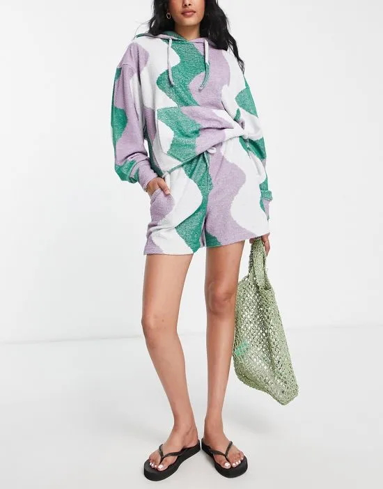 https://images.styletyx.com/images/wave-print-towelling-shorts-in-green-part-of-a-set-damson-madder-2801923_4.webp